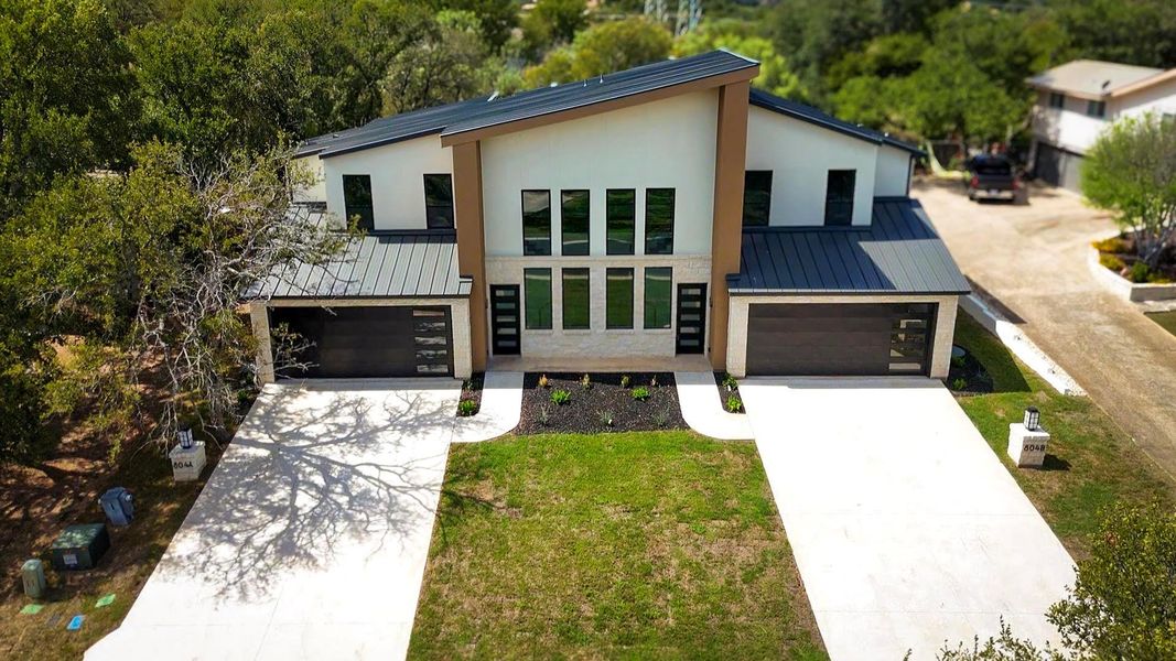 Contemporary home featuring a standing seam roof, a metal roof, and concrete driveway