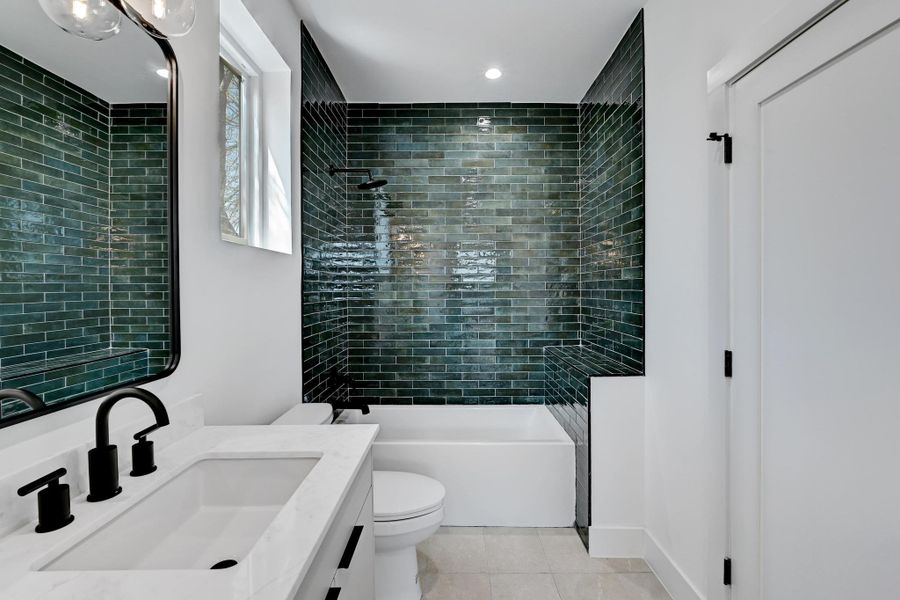 Bathroom featuring tile patterned floors, shower / tub combination and vanity