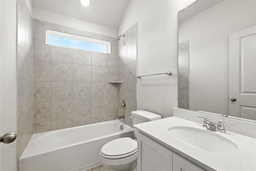 Full bath featuring vanity, washtub / shower combination, and vaulted ceiling