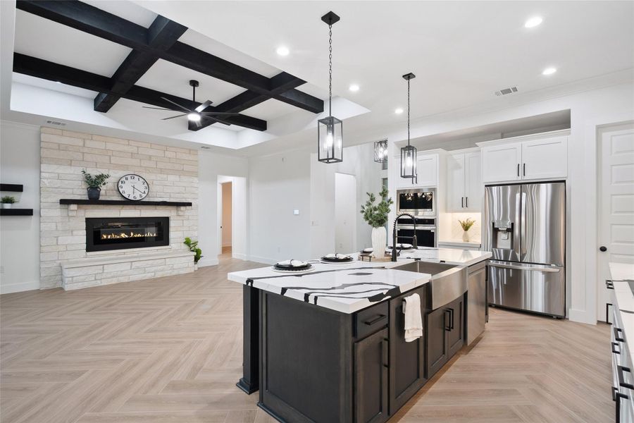 Kitchen with coffered ceiling, dark cabinets, stainless steel appliances, pendant lighting, and white cabinetry