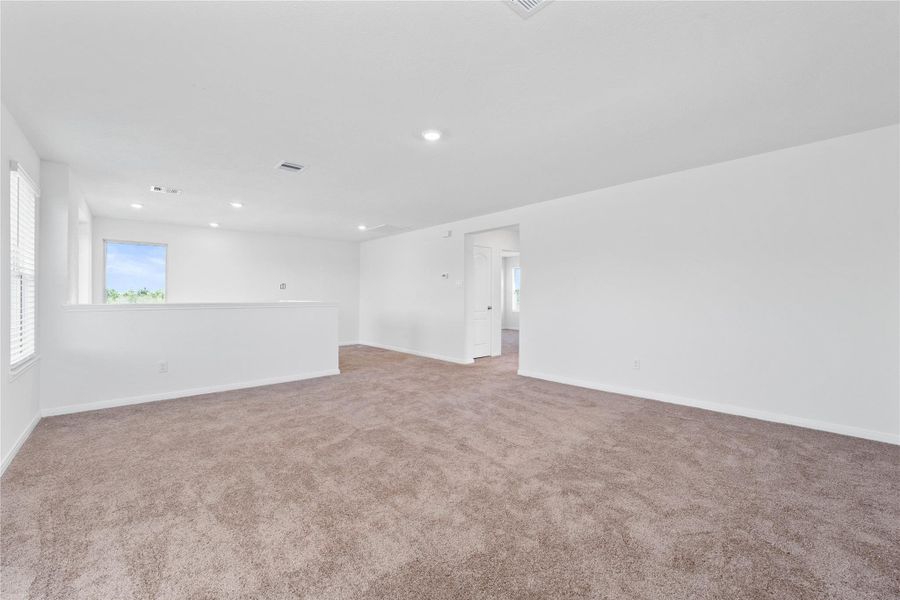 Another perspective of the Game Room, showcasing the staircase and hallway leading to the secondary bedrooms and bathroom. Another perspective of the Game Room, showcasing the staircase and hallway leading to the secondary bedrooms and bathroom.