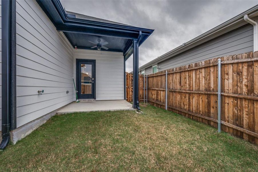 View of yard featuring ceiling fan and a patio