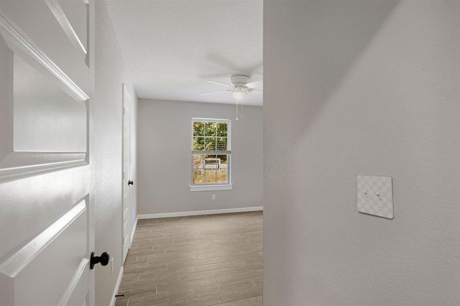 Empty room featuring wood tiled floors and a ceiling fan Empty room featuring wood tiled floors and a ceiling fan