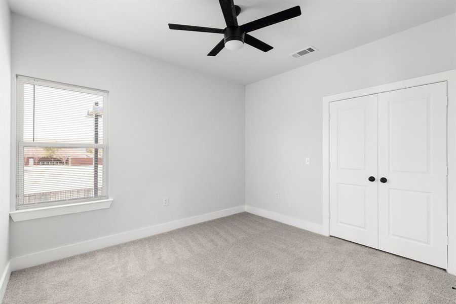 Unfurnished bedroom featuring ceiling fan, visible vents, baseboards, a closet, and carpet