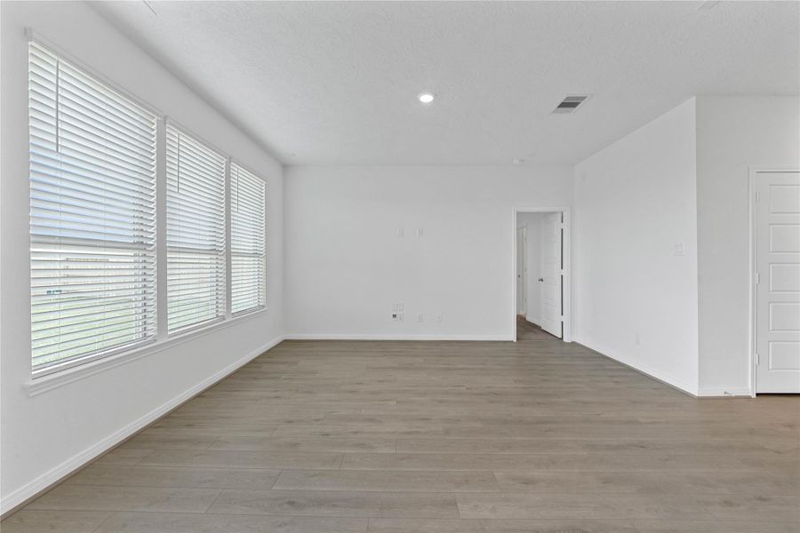 Flooded with natural light from large windows, the Great Room feels bright and airy. Recessed lighting adds to the welcoming atmosphere, perfect for gathering with family and guests.