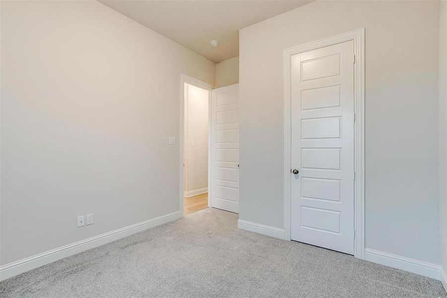 Unfurnished bedroom with light carpet and a closet