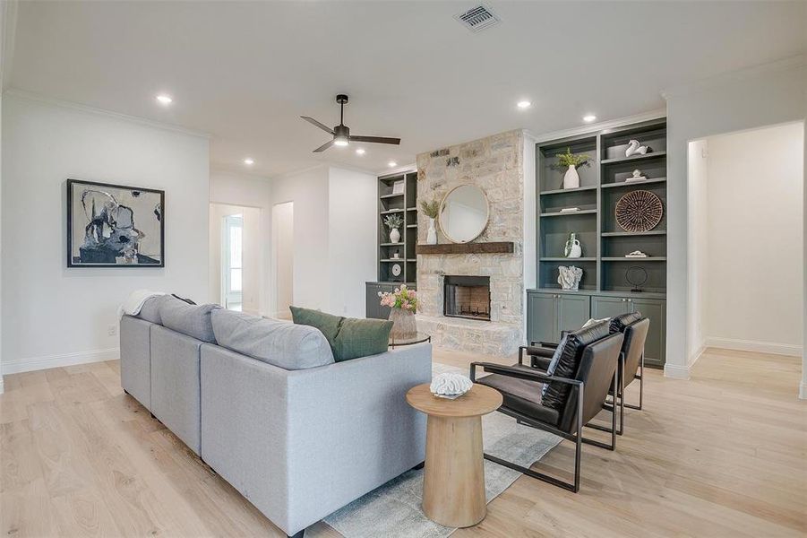 Living room with beautiful hardwood floors and 10 ft ceilings, fireplace with stone surround and cedar mantel.