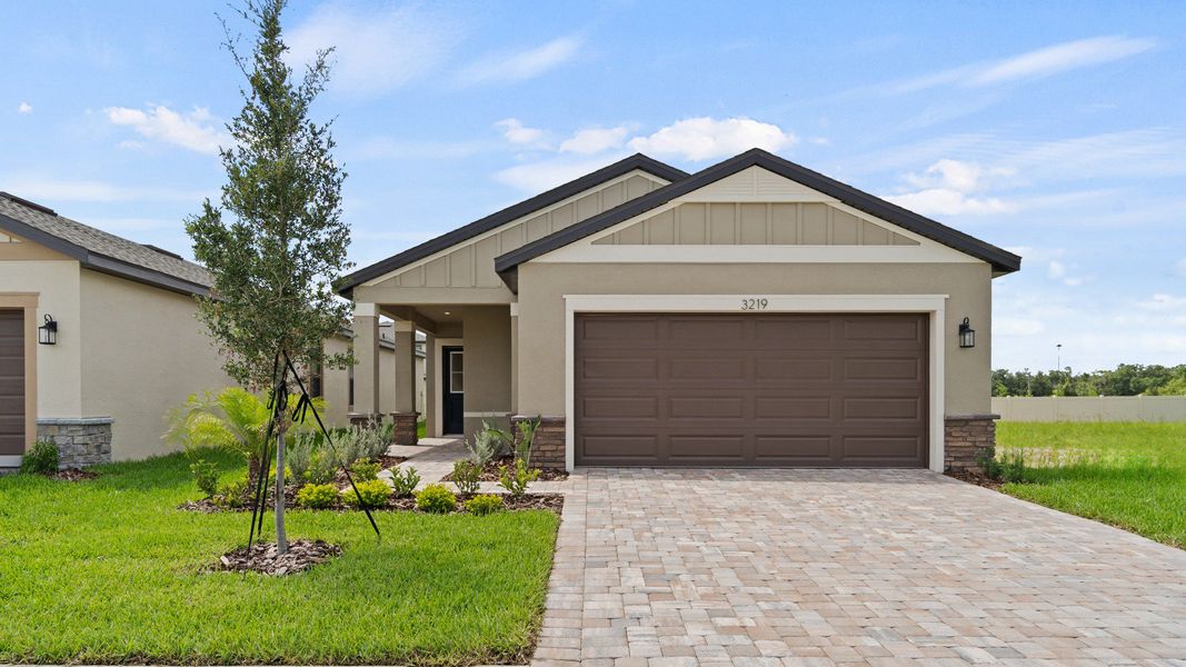 The Flagler at Grasslands West in Lakeland, FL offers a paver driveway, 2-car garage, and manicured landscaping.