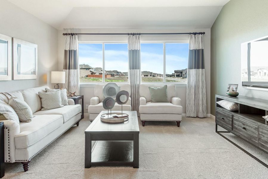 Living room with white sofa, two accent chairs, coffee table, and large windows with striped curtains Living room with white sofa, two accent chairs, coffee table, and large windows with striped curtains