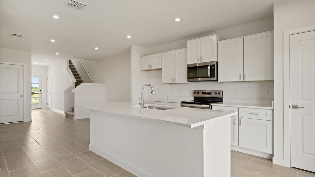 Open kitchen with a large island, natural light, and direct access to the backyard—perfect for cooking and entertaining