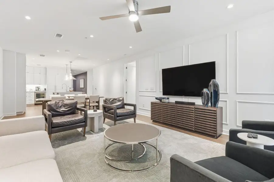 Living room featuring a decorative wall, light wood-style flooring, recessed lighting, wine cooler, and a ceiling fan