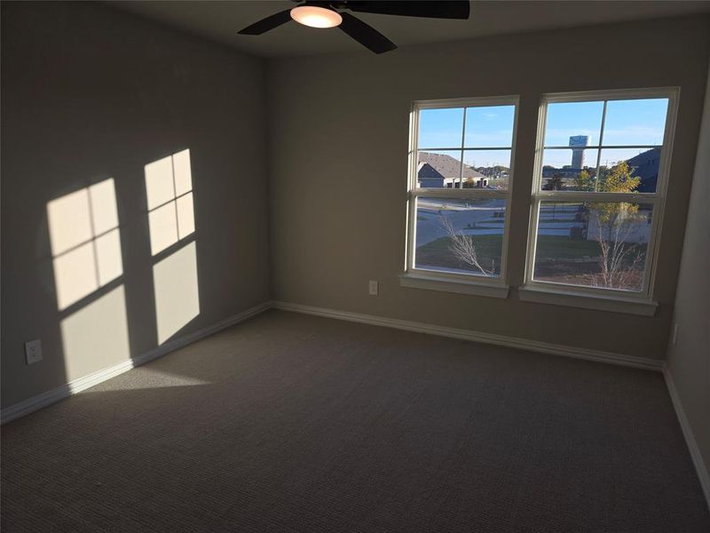 Spare room featuring ceiling fan and dark carpet