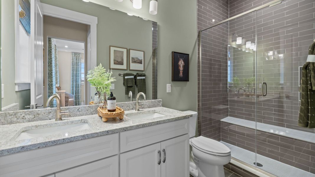 The Inspire Plan with a modern bathroom featuring a glass-enclosed shower lined with rich grey tiles in Fort Mill, SC