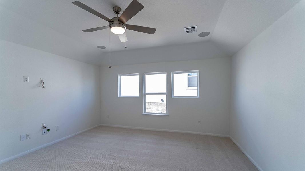 Spare room featuring light carpet, a ceiling fan, and vaulted ceiling