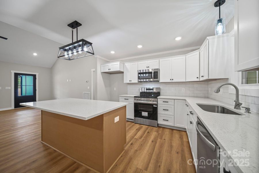Kitchen with quartz countertops, tile backsplash, custom cabinets, recessed lighting and stainless steel appliances. Kitchen with quartz countertops, tile backsplash, custom cabinets, recessed lighting and stainless steel appliances.