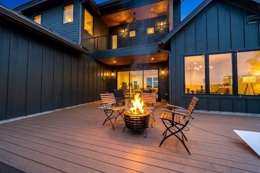 A spacious wooden deck transitions seamlessly into modern multi-level outdoor living spaces.