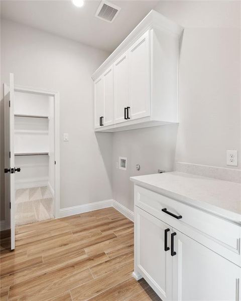 Clothes washing area featuring cabinets and washer hookup