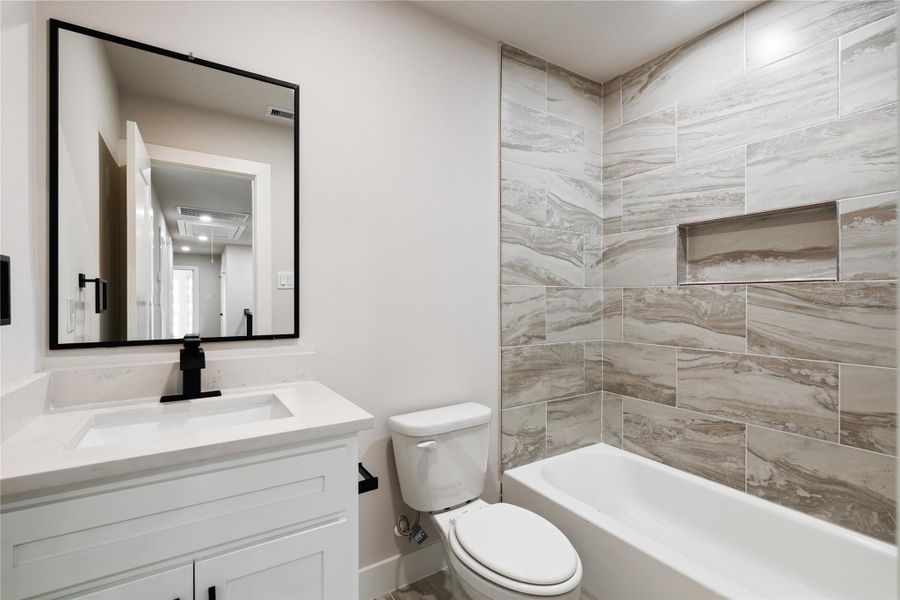 A beautifully finished bathroom continues the home’s modern style with sleek fixtures and eye-catching tilework. It’s a fresh, functional space designed for everyday ease and comfort.