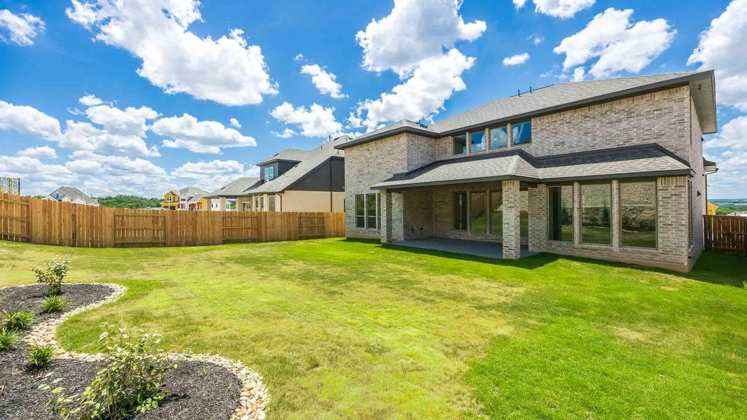 Rear view of house featuring a fenced backyard, a patio, and brick siding