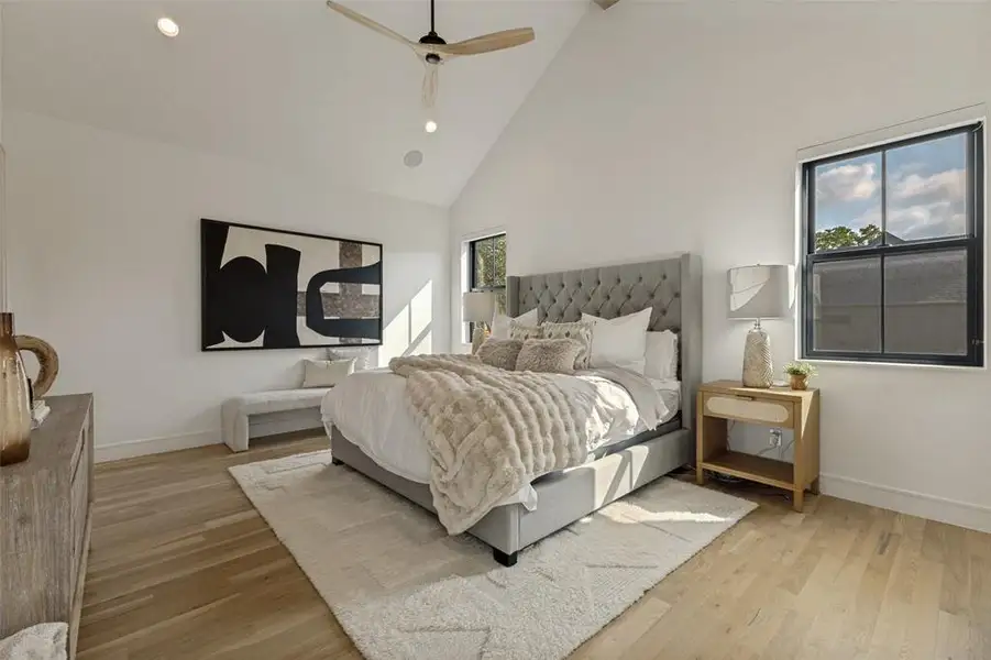 Vaulted ceiling bedroom featuring light wood-finish flooring, recessed lighting, and a modern ceiling fan Vaulted ceiling bedroom featuring light wood-finish flooring, recessed lighting, and a modern ceiling fan