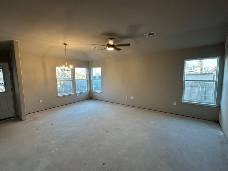 Unfurnished room featuring ceiling fan with notable chandelier