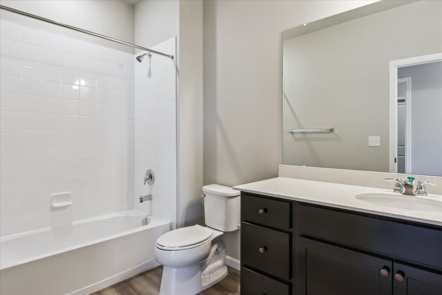 A bathroom with a tub sink and toilet.