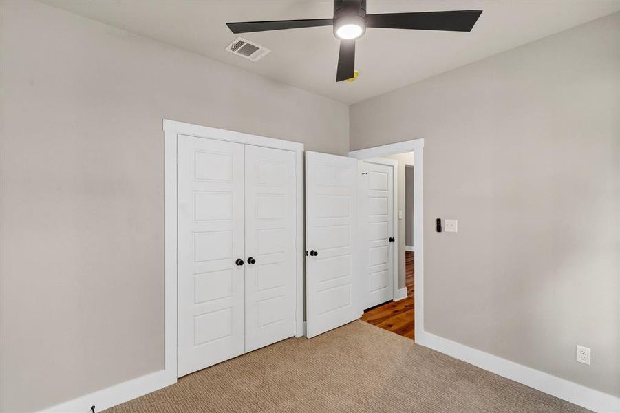 Unfurnished bedroom with carpet, a closet, and ceiling fan