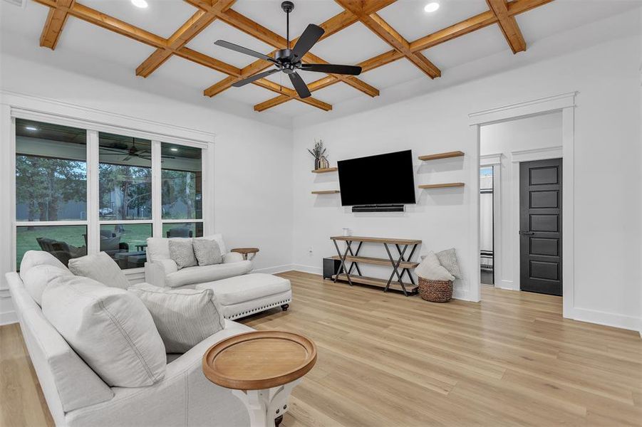 Open Living area featuring coffered ceiling, light wood-style floors, a ceiling fan, beamed ceiling, and recessed lighting Open Living area featuring coffered ceiling, light wood-style floors, a ceiling fan, beamed ceiling, and recessed lighting
