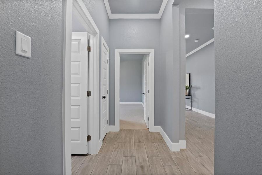 Interior hallway featuring wood-finish flooring, light grey walls, white trim, and recessed lighting