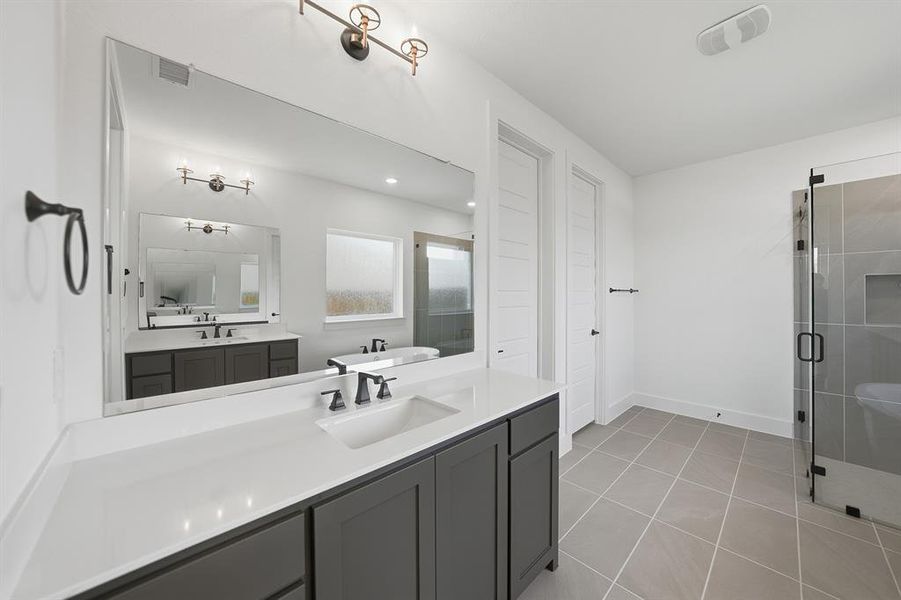 Bathroom featuring vanity, a shower stall, and light tile patterned flooring Bathroom featuring vanity, a shower stall, and light tile patterned flooring