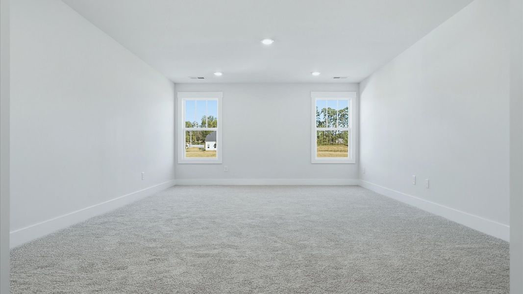Vibrant carpeted bonus room offering flexibility as a study nook, game room, or second family space at Mulberry Estates