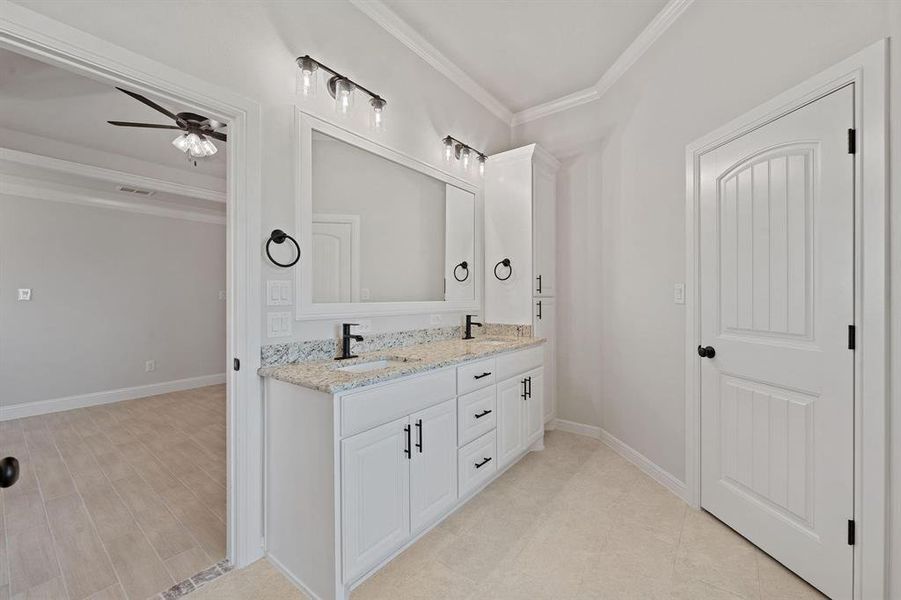 Full bathroom featuring ornamental molding, double vanity, and ceiling fan