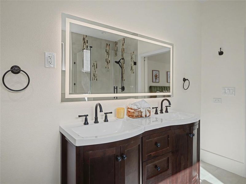 Bathroom with double vanity and a stall shower