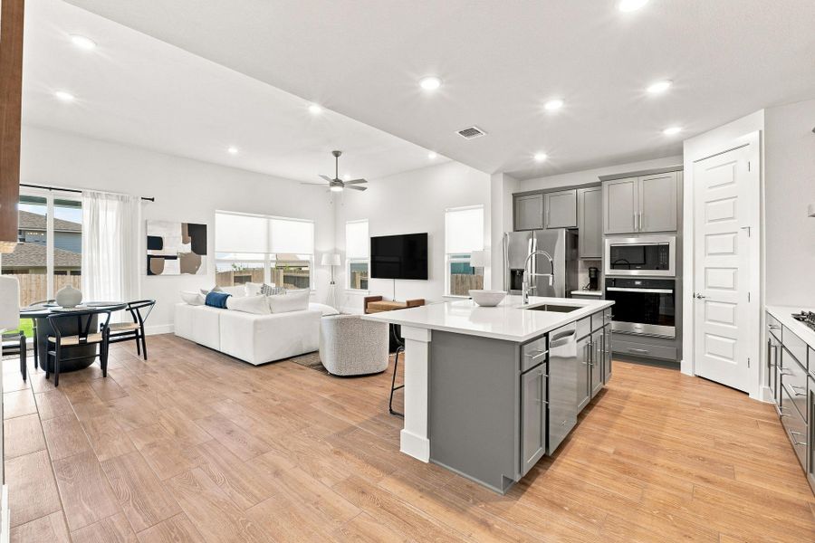 Open-concept main living space featuring Level 6 wood-plank tile flooring, recessed disc lighting, and effortless flow between living, dining, and kitchen. Open-concept main living space featuring Level 6 wood-plank tile flooring, recessed disc lighting, and effortless flow between living, dining, and kitchen.