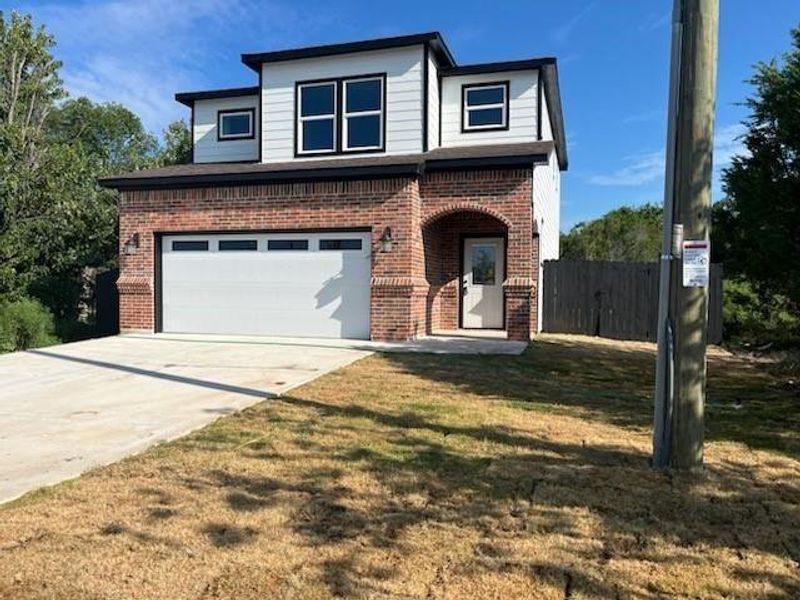 Traditional home with concrete driveway, brick siding, and a garage Traditional home with concrete driveway, brick siding, and a garage