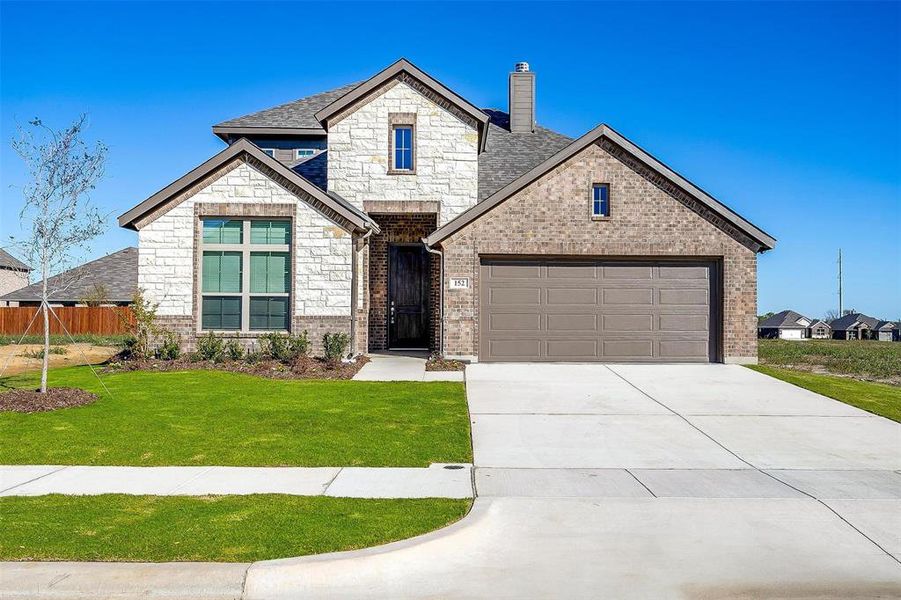 View of front of property featuring a garage and a front yard