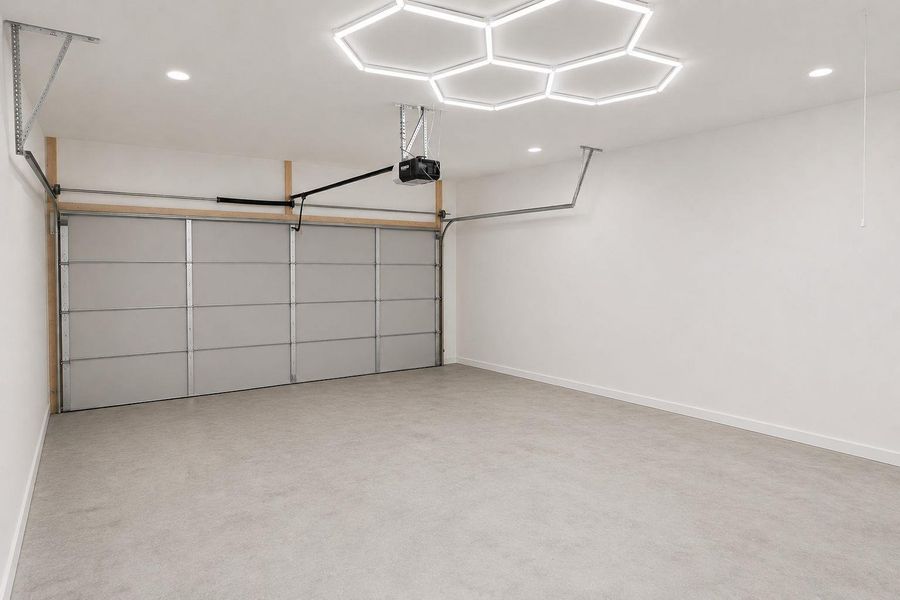 Ample space for vehicles and storage with durable concrete flooring and modern overhead lighting.