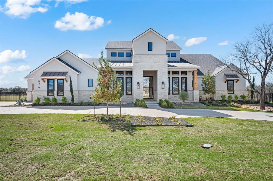 View of front of home with a standing seam roof and stone siding