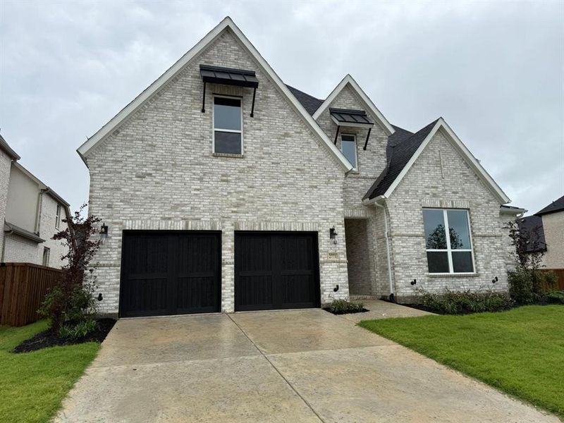 View of front of property featuring concrete driveway, brick siding, and a shingled roof View of front of property featuring concrete driveway, brick siding, and a shingled roof