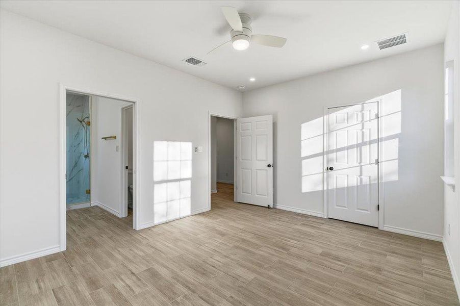 Unfurnished bedroom featuring light wood-style floors, a ceiling fan, recessed lighting, and ensuite bathroom