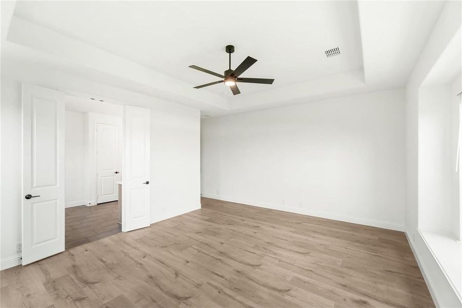 The Primary, located at the back of the home, offers so many nice features: High ceiling with Architecturally interesting detail work, a window seat and hard surface wood-look flooring.