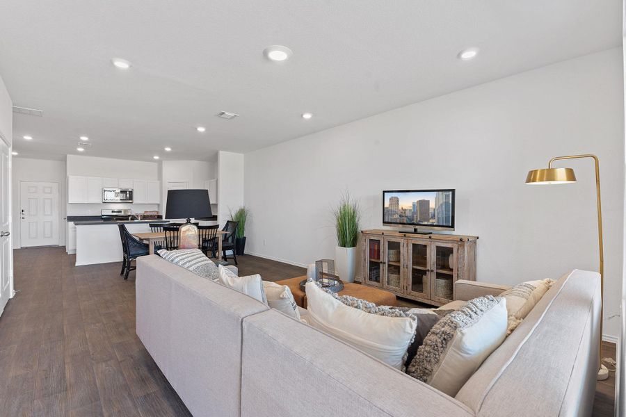 Living room with baseboards, visible vents, dark wood-type flooring, and recessed lighting