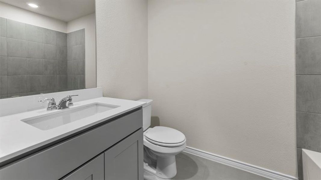 The bathroom features a vanity with a light gray cabinet and a white countertop with an integrated sink