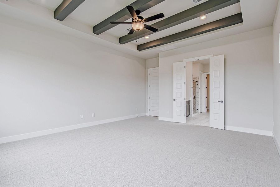 Primary bedroom with tray ceiling and generous space for comfort and relaxation.