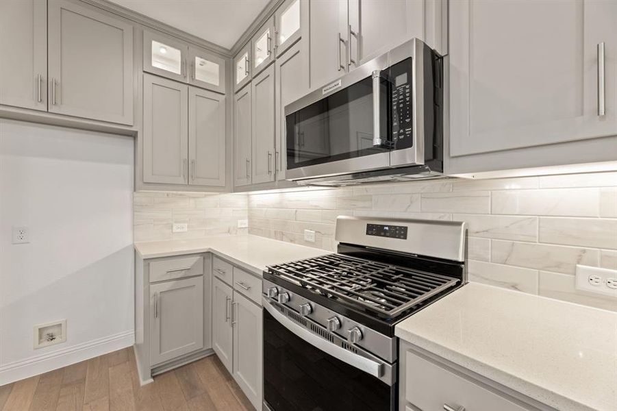 Kitchen featuring tasteful backsplash, stainless steel appliances, and light wood-type flooring