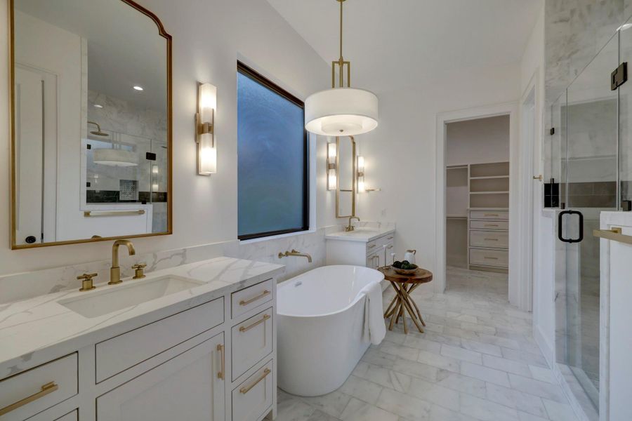 Primary bath with brass accents, double vanities, walk-in shower, soaking tub, tasteful finishes*photos are of a previously constructed home by the builder. 1527 Hewitt may have different selections at builders sole discretion. These photos are not meant to be an exact representation of 1527 Hewitt.