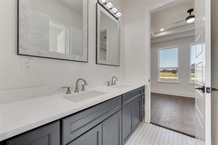 Dual vanity featuring white countertops, undermount sinks, and brushed nickel fixtures Dual vanity featuring white countertops, undermount sinks, and brushed nickel fixtures