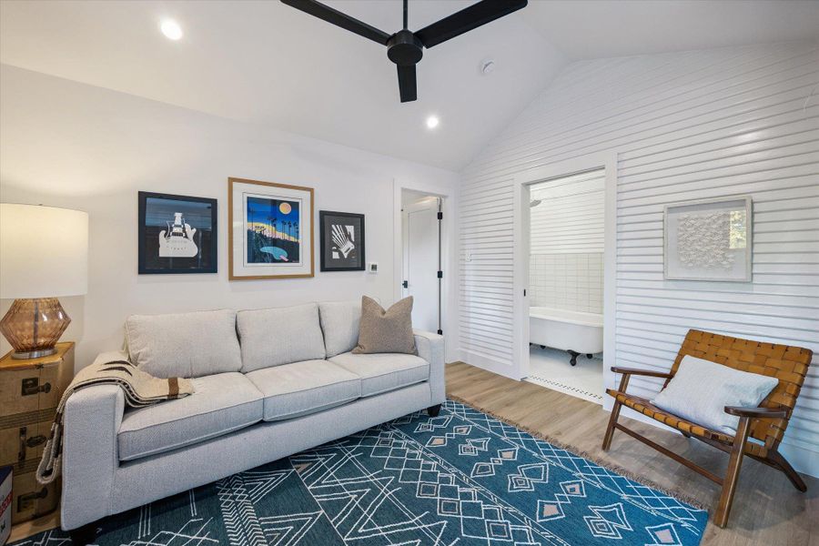 Living room featuring lofted ceiling, wood finished floors, recessed lighting, and a ceiling fan Living room featuring lofted ceiling, wood finished floors, recessed lighting, and a ceiling fan