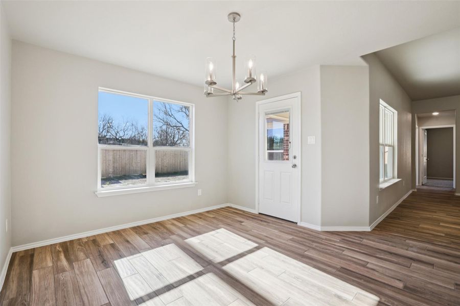 Unfurnished dining area featuring hanging lights and wood finished floors