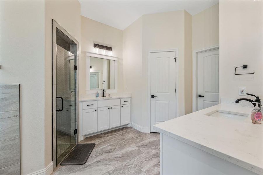 Full bath with a shower stall, two vanities, and light marble finish flooring Full bath with a shower stall, two vanities, and light marble finish flooring